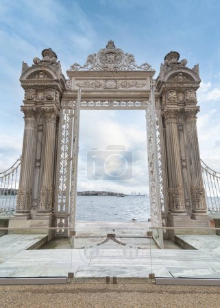 Pair of elaborately decorated white painted metal gates leading to the opulent Dolmabahce Palace in Istanbul, Turkey, and offering stunning views of the Bosphorus Strait