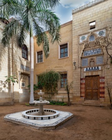 Ein ruhiger Innenhof mit Palmen und Marmorbrunnen am Prince Naguib Palace, der die Architektur der Mamluken in Kairo, Ägypten, präsentiert