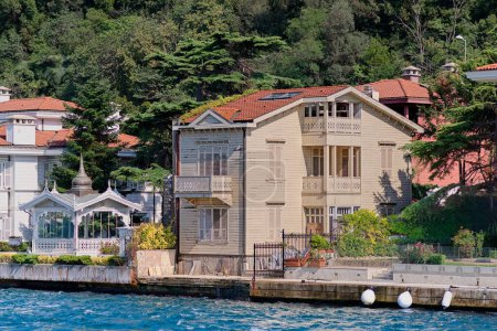 View from Bosphorus strait of the green mountains of the Asian side, with traditional houses and dense trees in a summer day, Istanbul, Turkey