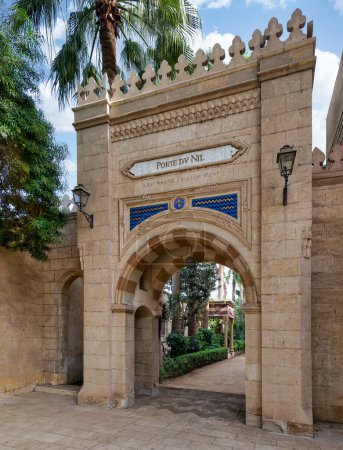 Un arco de estilo mameluco adornado conduce a un tranquilo jardín en Prince Naguib Place, El Cairo, Egipto, mostrando arquitectura histórica