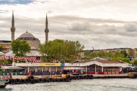 Foto de Estambul, Turquía - 10 de mayo de 2023: Uskudar ferry terminal bulle cerca de aguas tranquilas, con la histórica Mezquita de Mihrimah Sultan como telón de fondo. Tranquilo pero acogedor, espera el próximo ferry - Imagen libre de derechos