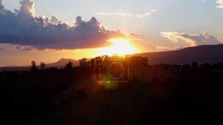Photo for Sunset in farming landscape at countryside rural scenery. Green forest trees between mountains. - Royalty Free Image