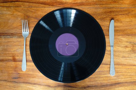 Photo for Vintage record instead of dinner plate with knife and fork. Good taste concept. - Royalty Free Image