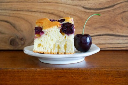 Photo for Cherry cake on white plate and wooden background. Selective focus. - Royalty Free Image