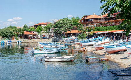 Photo for Nessebar, Bulgaria - August 19,2014: Fishing boats in the bay against the background of the old town of Nessebar, Bulgaria. - Royalty Free Image