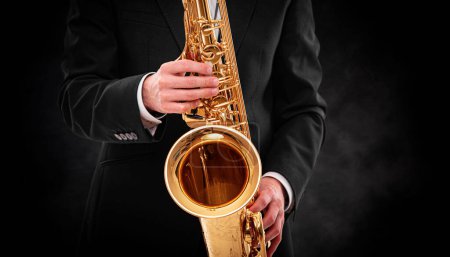 Téléchargez les photos : Saxophoniste sur fond noir close-up. - en image libre de droit