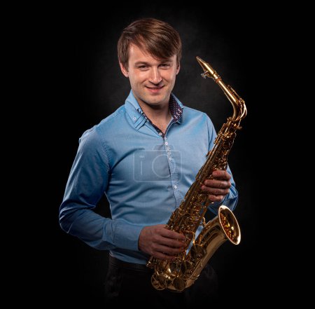 Téléchargez les photos : Saxophoniste sur fond noir close-up. - en image libre de droit