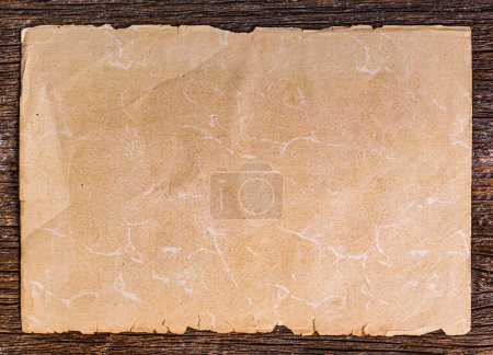 Photo for Sheet of old paper on a wooden background. Old paper on brown aged wood. - Royalty Free Image