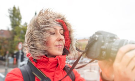 Foto de Mujer turista o fotógrafa en chaqueta de invierno con cámara en la calle. - Imagen libre de derechos