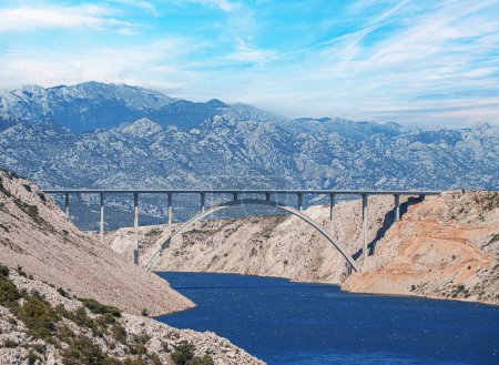 Photo for Concrete arch bridge with a road against the backdrop of mountains. - Royalty Free Image