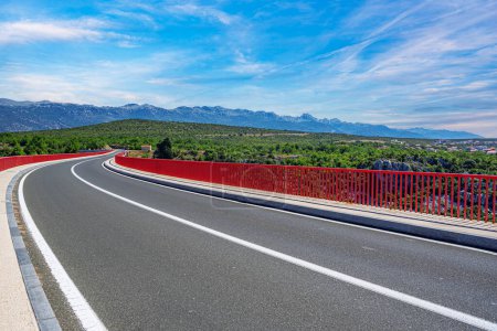 Photo for Iron arch bridge with a road against the backdrop of mountains. - Royalty Free Image