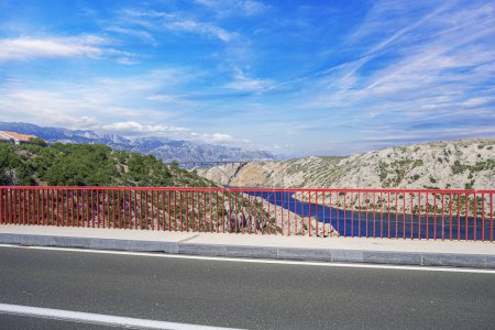 Photo for Iron arch bridge with a road against the backdrop of mountains. - Royalty Free Image