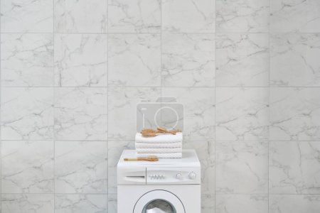 Foto de Cerca de la lavadora hasta el estilo con toalla, cepillo y kits de limpieza en la pared del cuarto de baño. - Imagen libre de derechos