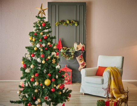 Téléchargez les photos : Nouveau concept de chambre intérieure de l'année avec cheminée noire, ornement d'arbre de Noël, fauteuil et boîte cadeau style. - en image libre de droit