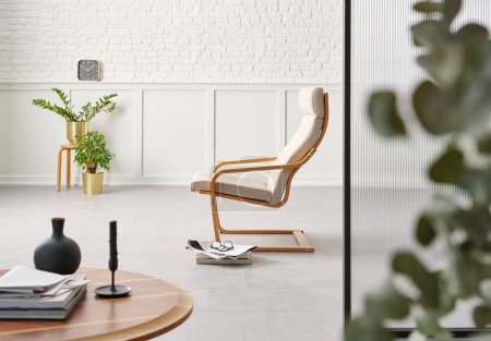 Foto de Rocker chair in the white room, brick and classic wall background, chamber, green plant leaf close up blur, working table. - Imagen libre de derechos