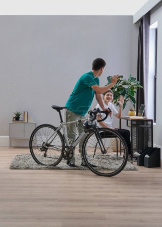 Foto de Dos hermanos hermano y hermana en la habitación, ella estudia y él anda en bicicleta. - Imagen libre de derechos