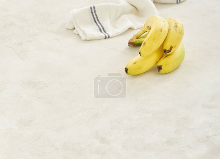 Foto de Los plátanos están en la mesa de hormigón gris, de cerca, fondo de servilleta blanco y azul. - Imagen libre de derechos