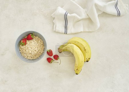 Photo for Bananas and granola in the cup, grey background top view. - Royalty Free Image