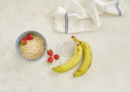 Foto de Plátanos y granola en la taza, fondo gris vista superior. - Imagen libre de derechos