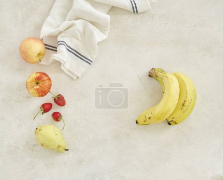 Téléchargez les photos : Les fruits sont sur le fond de la table en béton gris, pomme banane et serviette, tourné par le haut - en image libre de droit