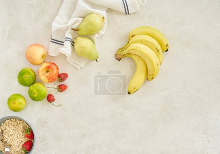 Téléchargez les photos : Bananes pomme et granola dans la tasse, fond gris vue de dessus. - en image libre de droit