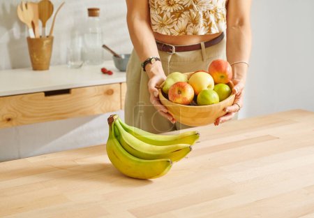 Photo for Close up fruit basket on the wooden table, kitchen, banana, apple and pear. Woman background style. - Royalty Free Image
