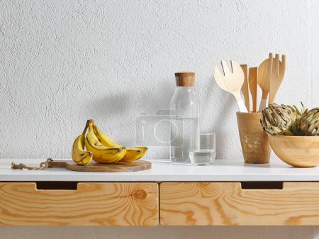 Téléchargez les photos : Banane jaune style cuisine, table en bois, planche à découper l'eau. Fourchette et cuillère en bois. - en image libre de droit