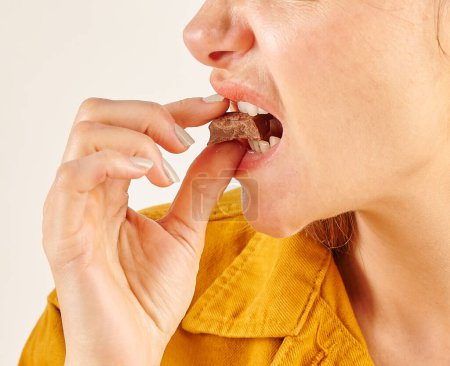 Foto de Mujer comiendo chocolate, primer plano, mano y boca. - Imagen libre de derechos