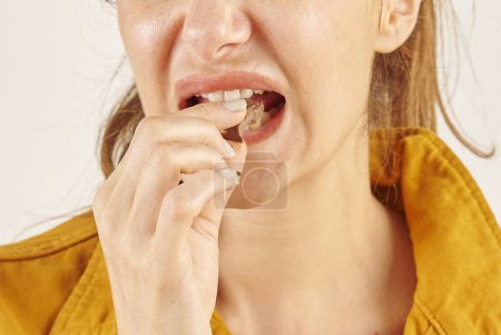 Téléchargez les photos : Femme mangeant du chocolat, gros plan, la main et la bouche. - en image libre de droit