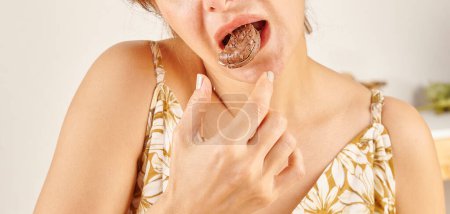 Téléchargez les photos : Femme mangeant biscuit, gros plan, la main et la bouche. - en image libre de droit