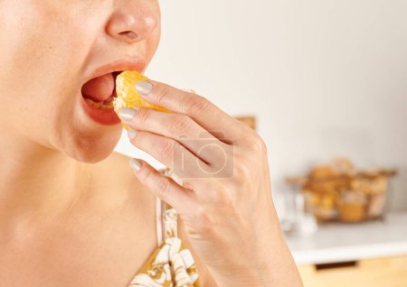 Téléchargez les photos : Femme mangeant mandarin, gros plan, la main et la bouche. - en image libre de droit