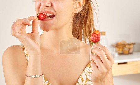 Téléchargez les photos : Femme mangeant fraise, gros plan, la main et la bouche. - en image libre de droit