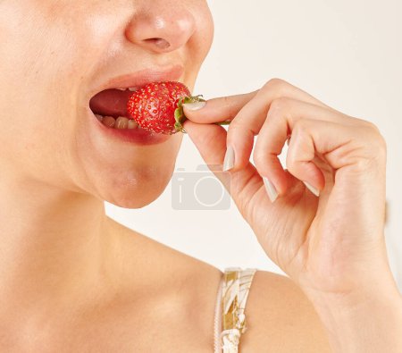 Téléchargez les photos : Femme mangeant fraise, gros plan, la main et la bouche. - en image libre de droit