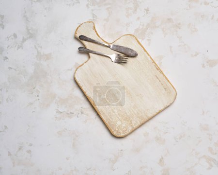 Photo for Wooden cutting board, decorative white ceramic background, up view. - Royalty Free Image