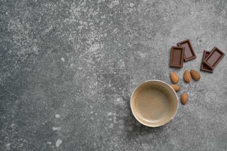 Foto de Estilo de café de vidrio de cerámica, chocolate y almendras en el fondo de la mesa de piedra, estilo decorativo gris. - Imagen libre de derechos