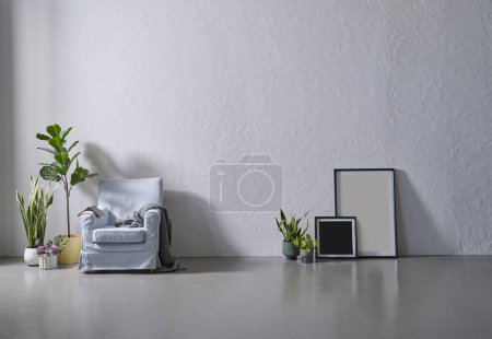 Photo for Grey stone wall background, frame, vase of green plant, sofa armchair blanket style, modern room. - Royalty Free Image