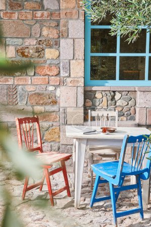 Téléchargez les photos : Maison en pierre, fenêtre décorative, jardin, chaise et table en bois, olivier, extérieur. - en image libre de droit