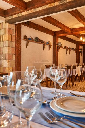 Foto de Piedra y madera concepto restaurante, mesa y silla, vasos, lugar de comida decorativa. Restaurante del hotel. - Imagen libre de derechos