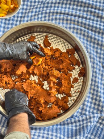 Téléchargez les photos : Steak tartare style turc, pétrir dans un bol en métal, main d'homme, en utilisant des gants, la culture traditionnelle, la fabrication de boulettes de viande crues. - en image libre de droit