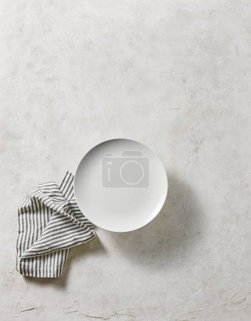 Téléchargez les photos : Assiette vide blanche, style de fond texturé décoratif avec serviette. Vue en haut. - en image libre de droit