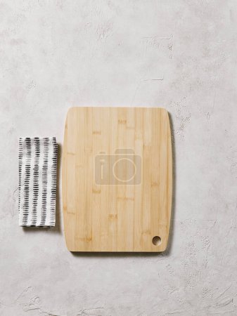 Téléchargez les photos : Planche à découper en bois sur la table décorative, vue d'en haut, serviette, vide, fond texturé. - en image libre de droit