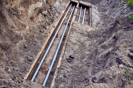 Foto de Fosa excavada con tuberías de aguas residuales de plomería de plástico para reparación e instalación - Imagen libre de derechos