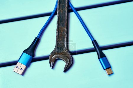 Photo for Old metal wrench, blue USB cable type c for charging and data transfer - Royalty Free Image