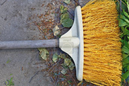 Photo for Yellow plastic mop sweeping trash in the yard - Royalty Free Image