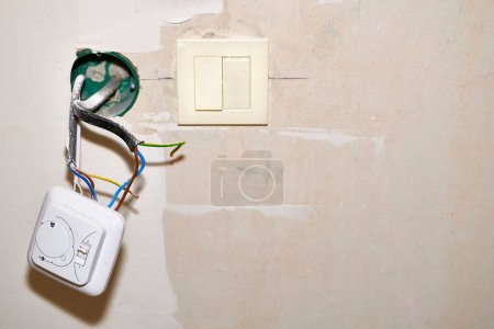 Photo for Installing and connecting a light switch into the wall - Royalty Free Image