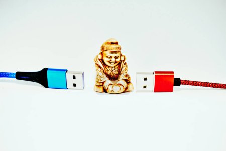 Buddhistischer Mönch, moderne Technologie Connect und Chat. Rote und blaue USB-Kabel                               