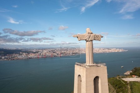 Photo for Aerial view monument Sanctuary of Christ the King. Majestic scenery statue with cityscape Almada and Tagus Riverin background. Birds eye view Catholic monument and city - Royalty Free Image