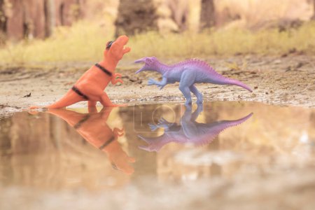 Téléchargez les photos : Dinosaur toys illustrating loitering around the lake - en image libre de droit