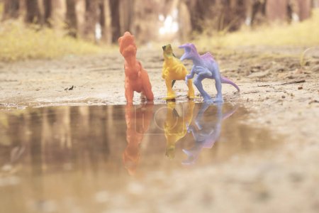 Téléchargez les photos : Dinosaur toys illustrating loitering around the lake - en image libre de droit