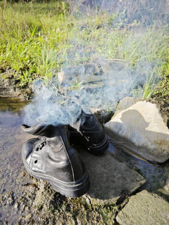Photo for Old thrown away leather boot on flame in the farm. - Royalty Free Image